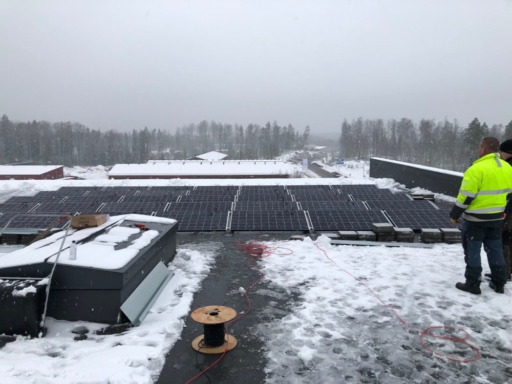 aurinkopaneelien asennusta lumisella katolla Scanoffice Solar