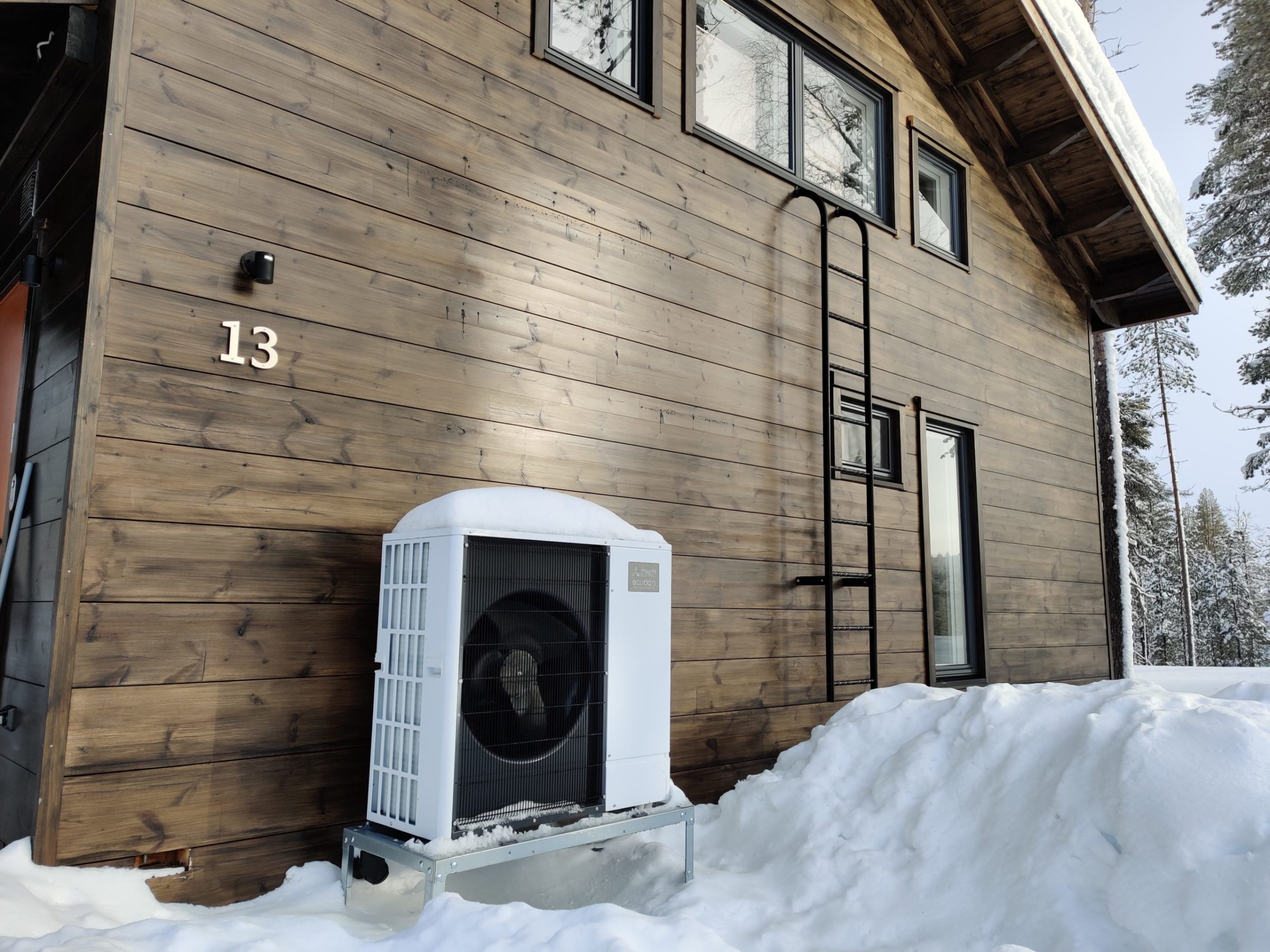 Mitsubishi Electric ilmavesilämpöpumppu tuottaa tehokkaasti lämpöä myös pakkasella. Ecodan-ulkoyksikkö talon seinustalla lumisena talvipäivänä.