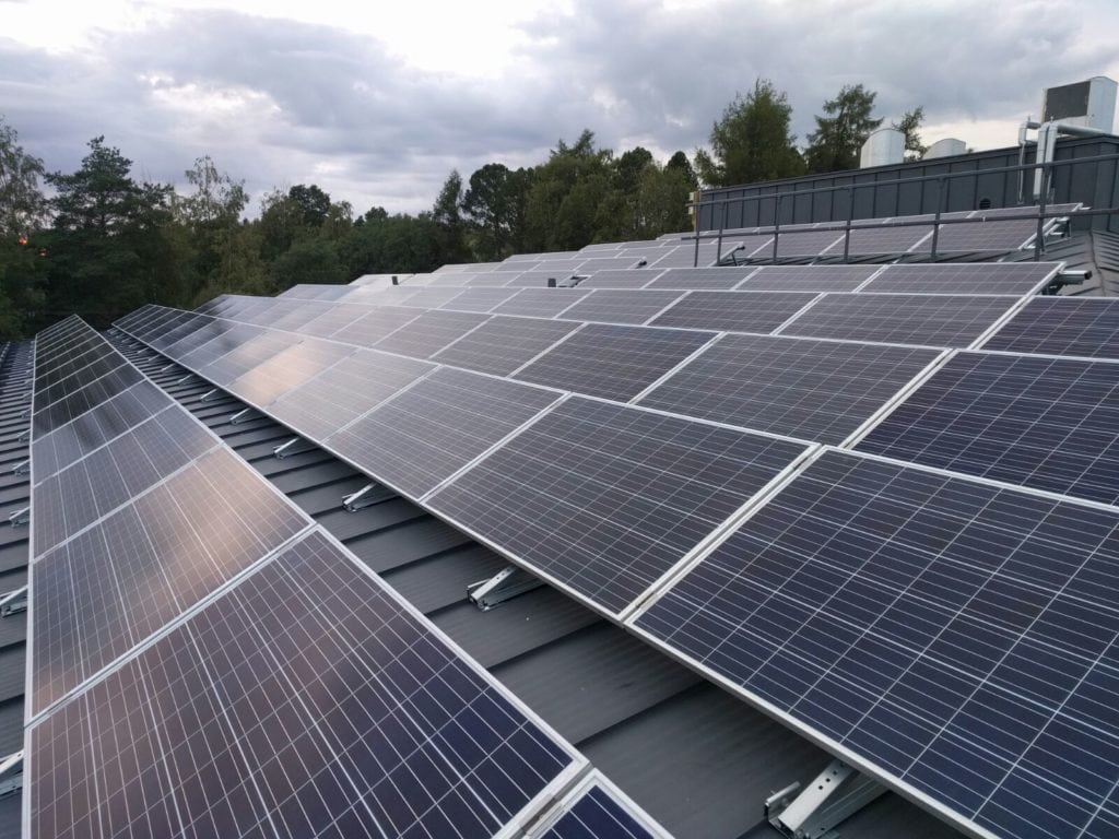 Orima Solar suomalainen aurinkopaneelien kattokiinnitysjärjestelmä 30 vuoden takuulla, kiinnikkeitä ja paneeleja talon katolla.