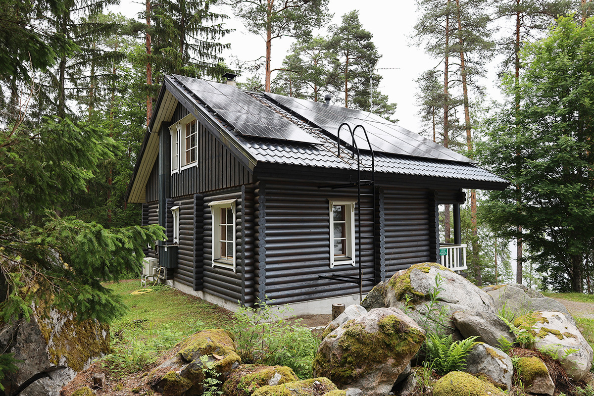 Mökki jonka katolla on aurinkopaneelit.